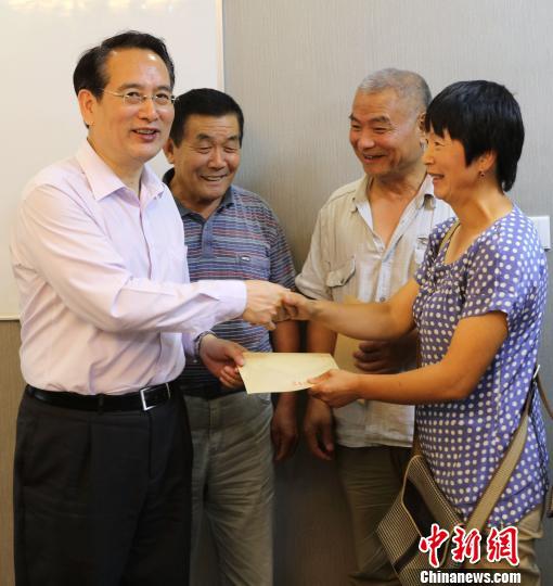 当地时间8月15日,中国国务院侨办副主任谭天星(左一)代表国侨办向当地困难华侨华人代表发放慰问金。 王修君 摄