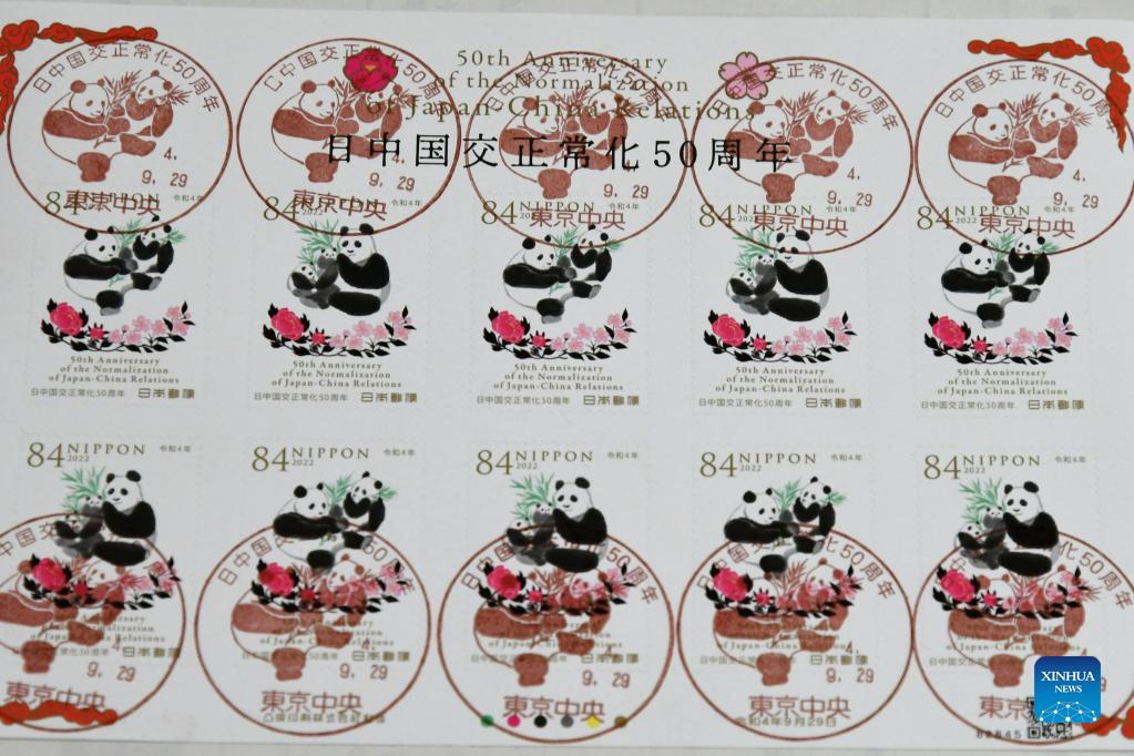 Photo taken on Sept. 29, 2022 shows the commemorative stamps marking the 50th anniversary of the normalization of diplomatic relations between Japan and China in Tokyo, Japan. Japan released a set of commemorative stamps on Thursday to mark the 50th anniversary of the normalization of diplomatic relations between Japan and China, with pictures of giant pandas eating bamboo surrounded by crimson peonies and pale pink cherry blossoms. Issued by Japan Post, the two stamps share a similar design featuring the ink wash painting style. One stamp shows a picture of a pair of adult giant pandas and the other depicts an adult giant panda with a pair of adorable giant panda cubs. (Xinhua/Hua Yi)