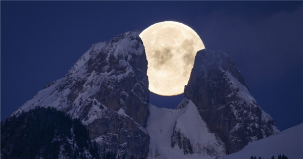 Spectacular scenery of full moon over mountain peaks