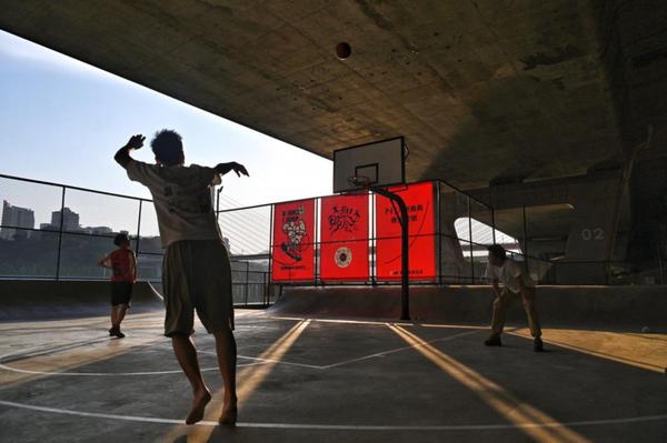 Residents play basketball on a court built underneath a bridge on Hongbin Road in Jiangbei district of Chongqing. (Photo by Li Ye/For chinadaily.com.cn)