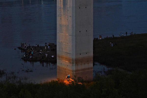 Under the pier of a bridge in Jiulongpo district of Chongqing, fishers choose their preferred spots for night fishing. (Photo by Li Ye/For chinadaily.com.cn)