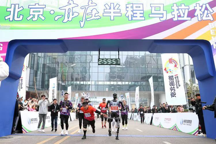 The 2024 Beijing Yizhuang Half Marathon is held, Nov. 10, 2024. The "Tiangong" robot, serving as a "closing rabbit" (a pacer who encourages and motivates runners to keep going), crosses the finish line alongside participants. (Photo/english.beijing.gov.cn)