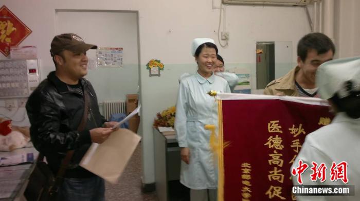 Aikeremu Aierken, a school counselor at Beijing University of Posts and Telecommunications, thanked doctors and nurses after the critically ill student recovered and was discharged from the hospital. (Photo provided by the interviewee)