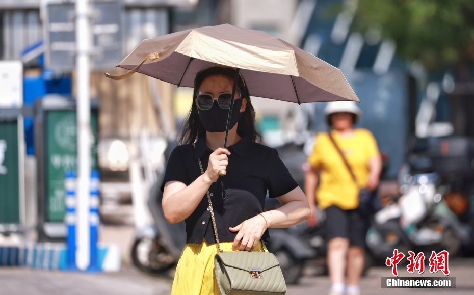 A woman holding an umbrella to block sunshine walks on a street in Beijing, June 23, 2025. (Photo/China News Service) A woman holding an umbrella to block sunshine walks on a street in Beijing, June 23, 2025. (Photo/China News Service)