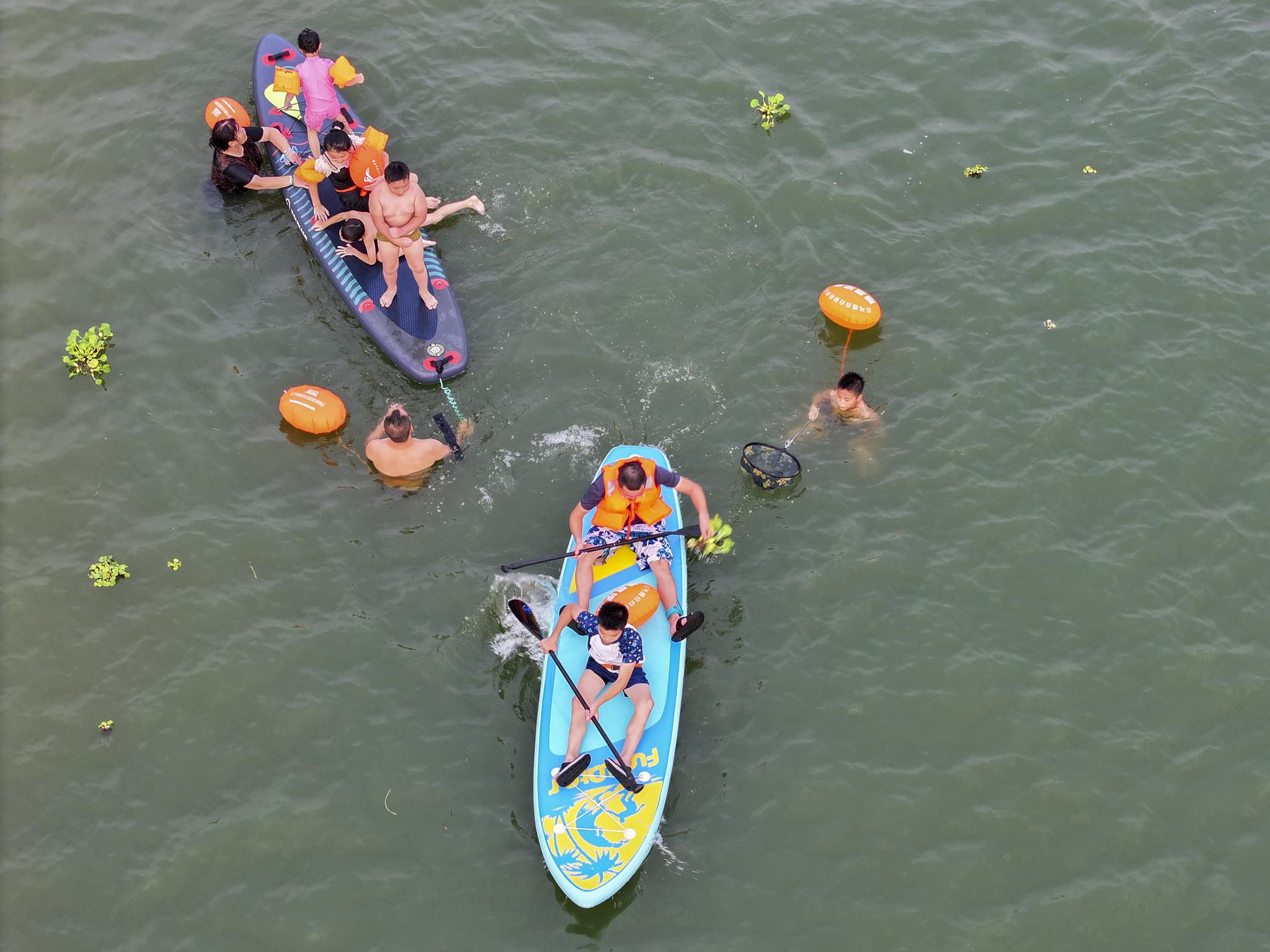 Stand-up paddleboarding popular among citizens in central China City to beat summer heat