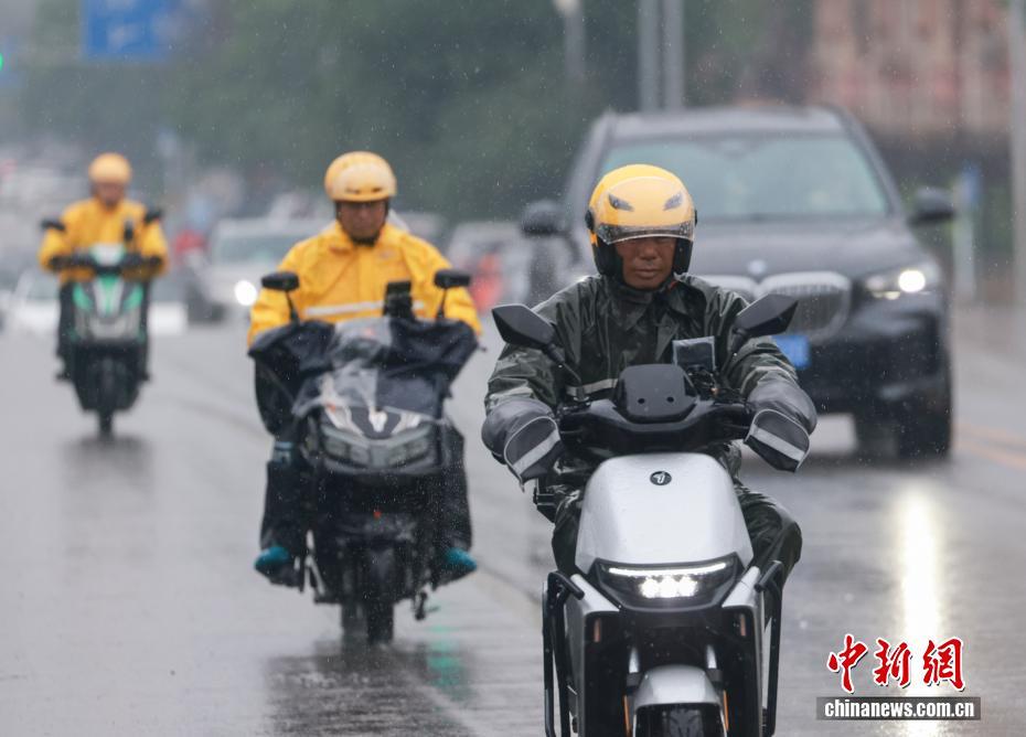 A food delivery rider delivers an order to a customer in the rain. (Photo/China News Service)