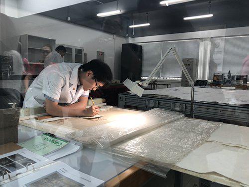 An expert at the Palace Museum's Relic Hospital restores a painting. (Photo: Luo Yunzhou/GT)