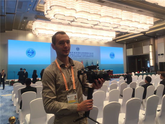 Yan Pachkevitch, a reporter from Belarus 1 TV, poses for a photo in Qingdao for the 18th Shanghai Cooperation Summit, June 10, 2018. (Photo by Guo Rong/chinadaily.com.cn)