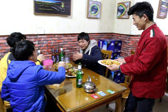 Liang serves customers at the eatery in Jinan, Shandong Province.  (Photo by Zheng Tao/For China Daily)