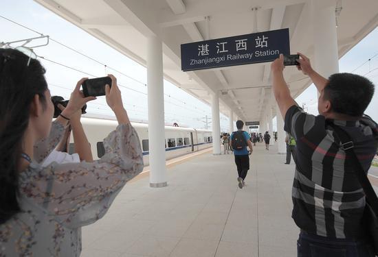 Visitors take pictures of the station board at Zhanjiangxi railway station in Zhanjiang, Guangdong Province. (Photo by Wu Weihong/For China Daily)