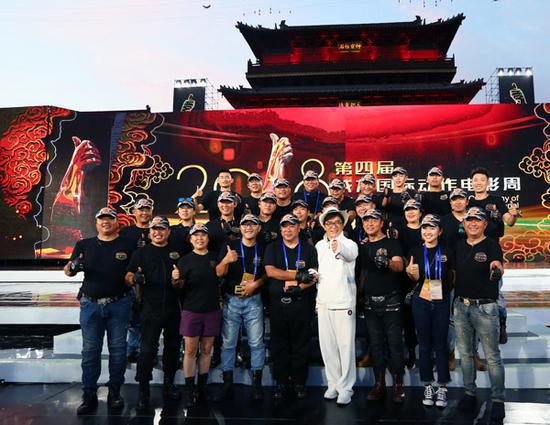 Chan with stunt performers at the movie week. 
(PHOTO BY FENG YONGBIN/CHINA DAILY)