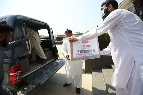 Workers carry donated face masks at Chinese Embassy in Pakistan on March 20, 2020 in Islamabad. (Xinhua/Liu Tian)