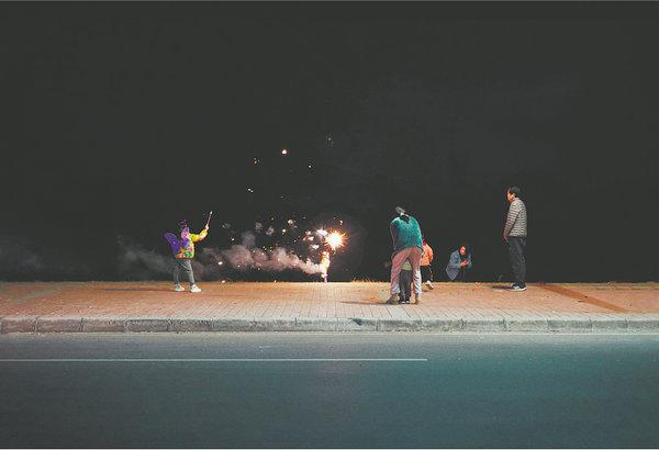 Scenes of night life in the suburbs of Guangzhou, Guangdong province, captured by Yan: A family setting off fireworks. [Photo by YAN JIACHENG/FOR CHINA DAILY]