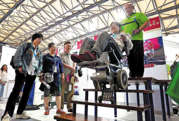 A woman tries a stair climber during the International Exhibition of Senior Care, Rehabilitation Medicine and Healthcare Shanghai 2025 on June 11. (GAO ERQIANG/CHINA DAILY)