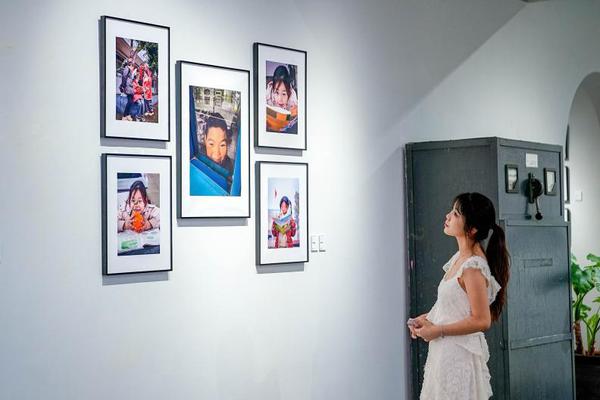 A visitor enjoys the photos taken by students participating in the Today at Apple Creative Camp in Beijing. [Photo provided to chinadaily.com.cn]