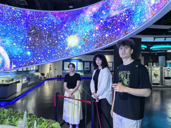 Hasanbayev Agabek (right), a student from Turkmenistan, visits the Museum of Xi'an University of Electronic Science and Technology. [Photo provided to chinadaily.com.cn]