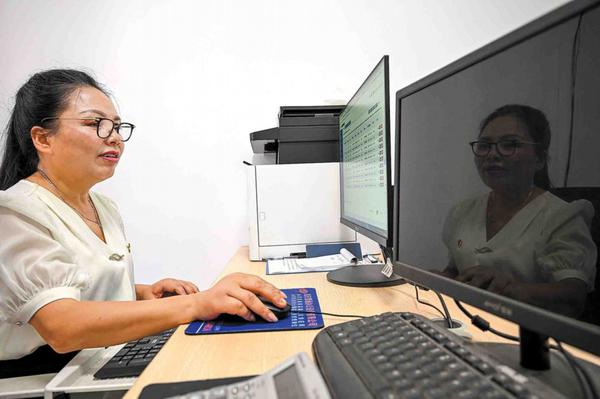 Community worker Jiang Chunyan collects data through the "one-form "system in Shuangshi county, Chongqing, on Friday. CHEN CHENG/XINHUA