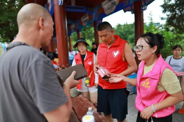 Volunteers distribute emergency food aid in the flood-stricken Rongjiang county, Southwest China's Guizhou province, June 29, 2025. [Photo/Xinhua]