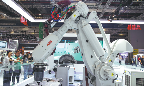 People view and take pictures of an industrial robot from Swiss technology company ABB during the China International Industry Fair in Shanghai on Sept 25, 2024. CHINA DAILY