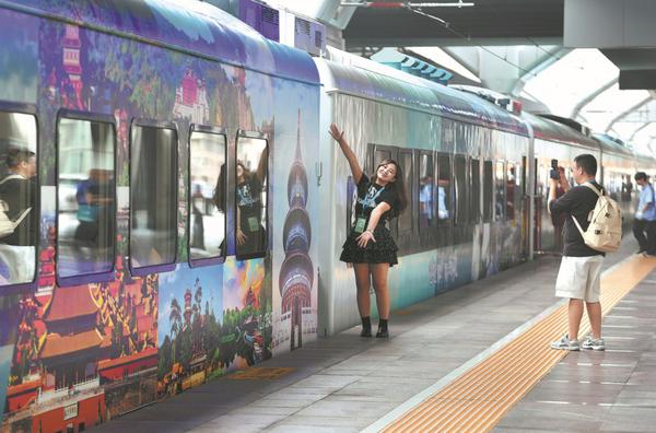 A passenger takes a picture at the Beijing Railway Station before boarding the Star Express, the first sightseeing tourist train in the Beijing-Tianjin-Hebei region on Wednesday. [Photo by Yuan Yi/For China Daily]
