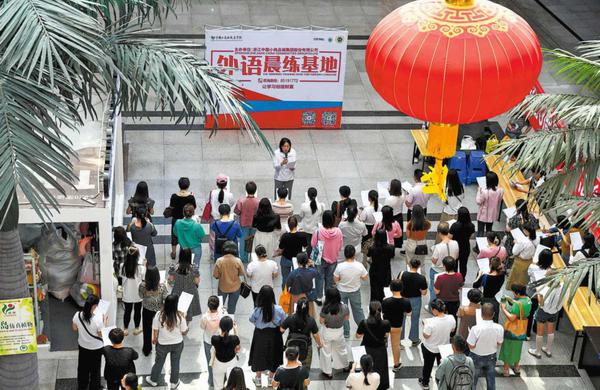 Shop owners follow a teacher's instructions during an English-language morning practice session at Yiwu International Trade City, Zhejiang province, on May 15, 2024. SHI KUANBING/FOR CHINA DAILY