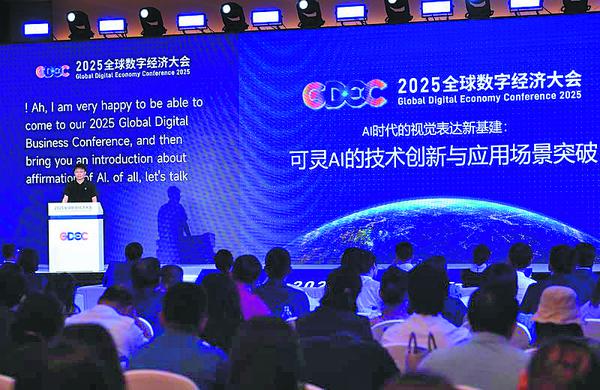 Zhang Di, vice-president of Kuaishou Technology and technical head of Kling AI, speaks at the Global Digital Economy Conference 2025, with AI-generated English subtitles behind him. ZHANG CHENLIN/XINHUA