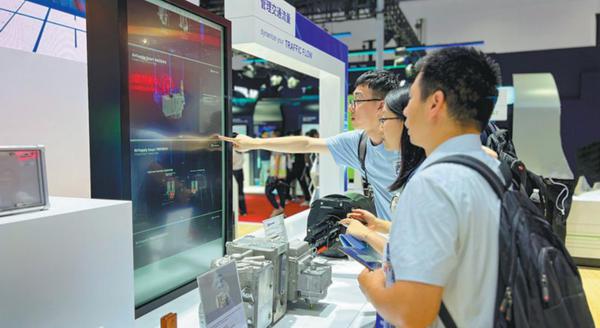  Visitors check out an intelligent air source system at the Knorr-Bremse booth in Beijing in July. [Photo provided to China Daily]