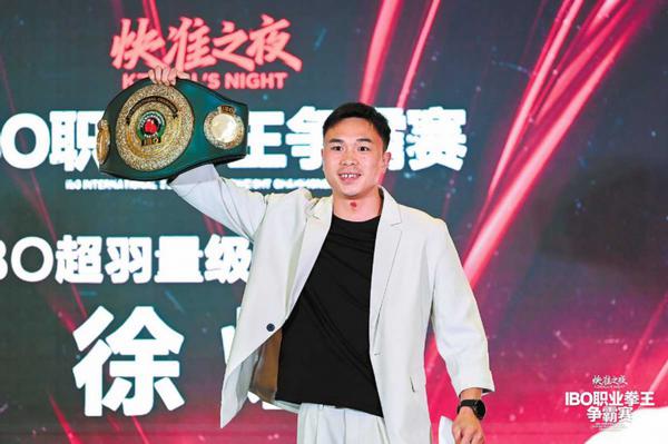 Xu Can hoists his IBO international belt ahead of his defense against Jaouad Belmehdi of France on Aug 15. PROVIDED TO CHINA DAILY