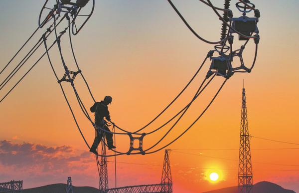 An employee inspects cables before the operation of a power line in Hinggan League, Inner Mongolia autonomous region, in June. WANG ZHENG/FOR CHINA DAILY