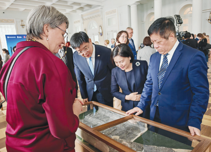  China's Ambassador to Russia Zhang Hanhui (first from right) and other guests look at cultural relics in the collection of the Russian National Library on Aug 14. LIU HONGJIE/CHINA DAILY