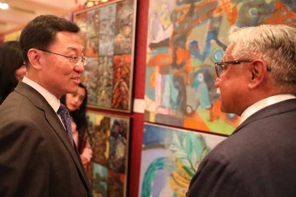  Chinese Ambassador to the US Xie Feng talks with a guest at the Chinese embassy in Washington on Wednesday at an art exhibition marking the 80th anniversary of the victory in the Chinese People's War of Resistance Against Japanese Aggression and the World Anti-Fascist War. [Photo by Zhao Huanxin/chinadaily.com.cn]