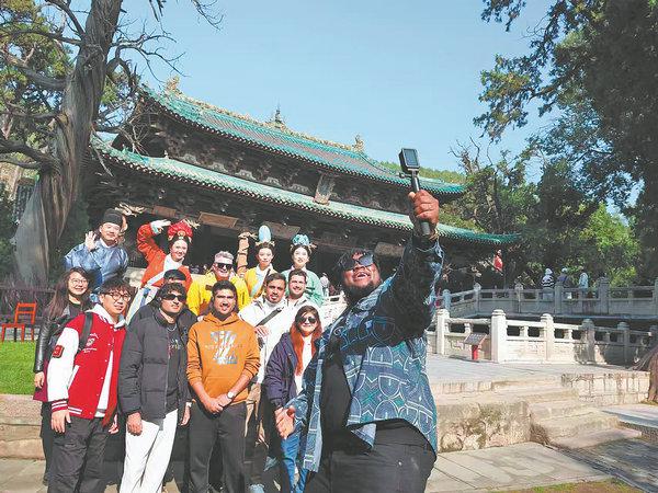 Nigerian blogger Oluwabunmi Henry Jimoh films the group at Jinci Museum in Taiyuan. [Photo/WEI BO/YAN CHANGJIANG/FOR CHINA DAILY]