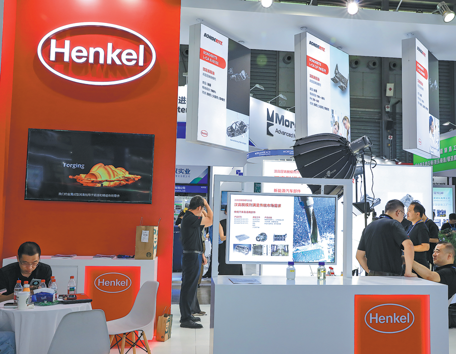  Visitors gather at Henkel's booth during a trade expo in Shanghai in July. CHINA DAILY