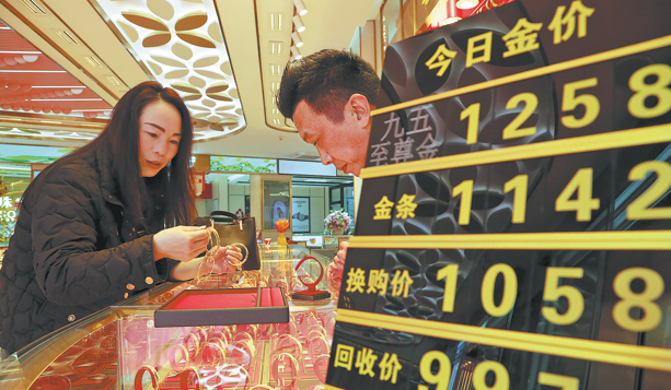 &nbsp;A shopper (right) looks at gold ornaments at a jewelry store in Mengzi, Yunnan province. XUE YINGYING/FOR CHINA DAILY