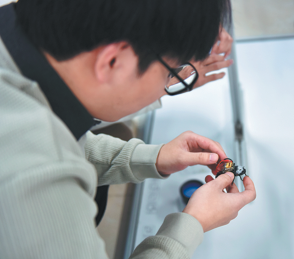 A researcher holds a cyborg cockroach in Qingdao, Shandong province. (Photo: China Daily)