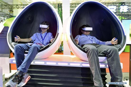 People experience a technology equipment combining VR and Dynamic Simulation during the 21st China Beijing International High-Tech Expo in Beijing, capital of China, May 17, 2018. The four-day expo opened here on Thursday. (Xinhua/Wang Jingsheng)
