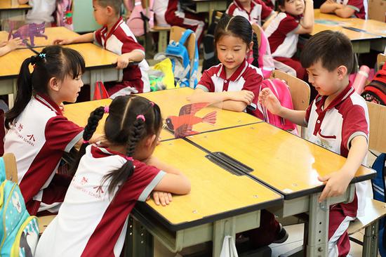 Two students read a storybook from the Kids Read project at the Peking University-affiliated Elementary School’s Fengtai campus in Beijing on May 17, 2018. (Photo provided to chinadaily.com.cn)
