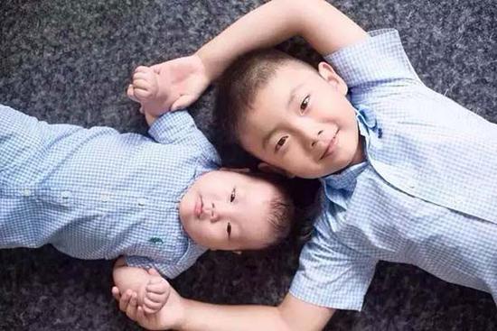 A boy with his younger brother.  (Photo provided to chinadaily.com.cn)