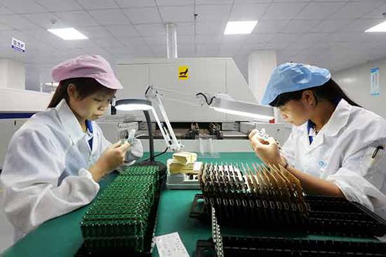 Technicians check chips at a technology company in Guigang, the Guangxi Zhuang autonomous region. (Photo by Tan Kaixing/for China Daily)