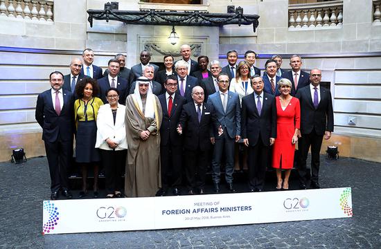 State Councilor and Foreign Minister Wang Yi, left of Australia's Julie Bishop, attends the G20 Meeting of Foreign Affairs Ministers in Buenos Aires, Argentina, on Monday with other foreign ministers. He called for boosting multilateralism and the G20's role in global governance in a speech.(Photo/Xinhua)