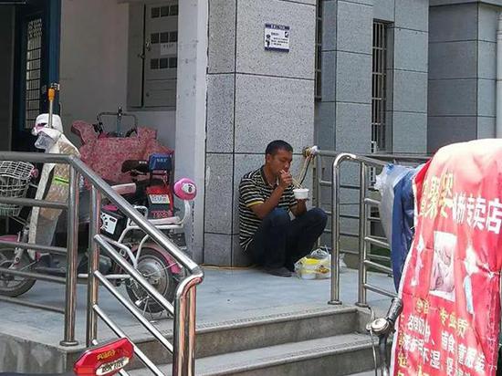 Yu Cong, a police officer at Bailang Police Station in Shiyan City, Hubei Province, squats on a street corner eating a bowl of instant noodles, to stake out suspects. (Photo provided by Bailang Police Station)