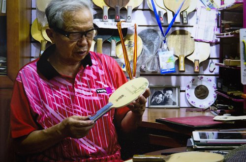 Cao Lixi holds a paddle produced in his workshop. (Photo/Courtesy of Wu Wei)