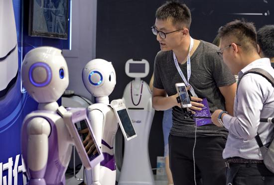 Multi-functional robots developed by iFlytek Co Ltd are displayed at the 2017 World Robot Conference in Beijing. (Photo/Xinhua)