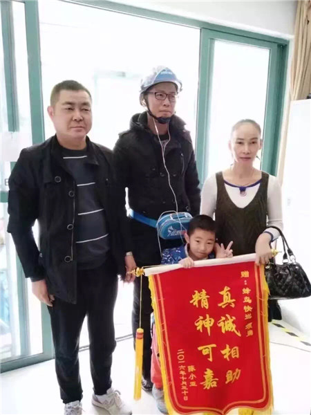In 2016, a delivery worker for Eleme receives a silk banner for helping to find a missing child. （Photo provided to chinadaily.com.cn）