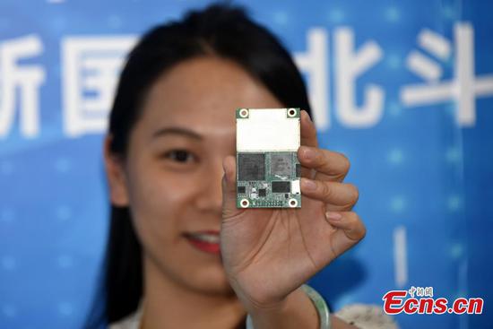 A worker shows radio frequency chip Hengxing-1 at the ninth China Satellite Navigation Conference in Harbin, capital of Heilongjiang province, May 24, 2018. [Photo: Photo: China News Service/ Sun Zifa]