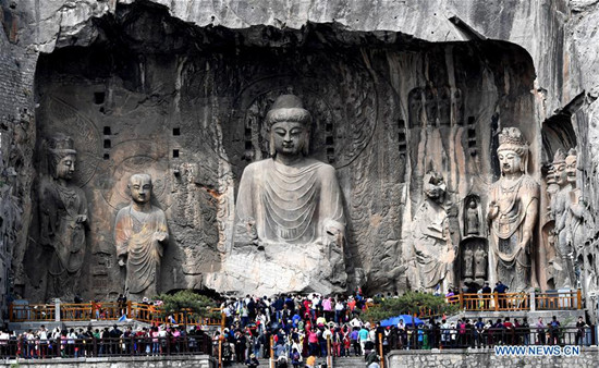 People visit the Longmen Grottoes in Luoyang, central China's Henan Province, April 11, 2018. The Longmen Grottoes has started to greet its boom season for tourism since April. (Xinhua/Zhu Xiang)
