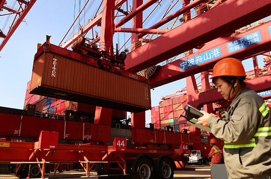 A worker monitors container operation at Zhoushan port in Ningbo, Zhejiang province. (Photo/China Daily)