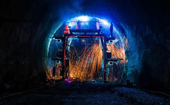 Welders work on supporting structures inside the Dazhongshan Tunnel earlier this month in Sanmenxia, Henan Province.  (Photo by China Daily)