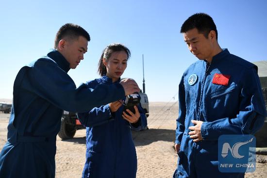Wang tests the satellite phone before setting out for the training. (Xinhua photo/Chen Bin)