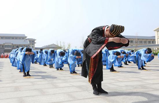 Convicts at Changtai Prison in Tianjin recite poetry at the opening ceremony of the annual Inmates' Sports Festival. The prison has launched a training center to teach long-term inmates about the modern world to help ease their transition when they are released. (Photo/China Daily)